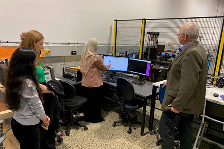 Group of students in a lab focused on a computer